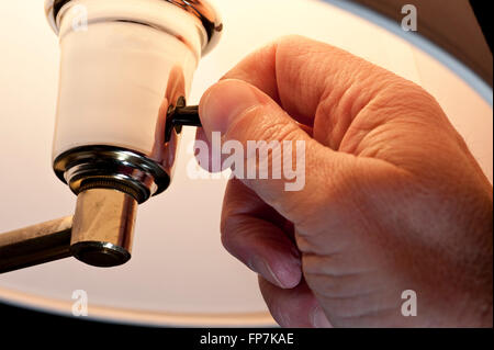Hand Turning On Lamp Stock Photo