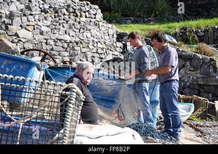 Fishermen mending nets in cadgwith harbour Cornwall,UK Stock Photo