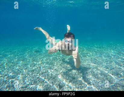 Young beard man with mask diving in a blue clean water Stock Photo
