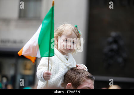 New York City, USA, 17 March 2016. St Patrick's Day parade:  Little girl rides in father's shoulders while clutching Irish flag along St Patrick's Day parade route Credit:  Andrew Katz/Alamy Live News Stock Photo