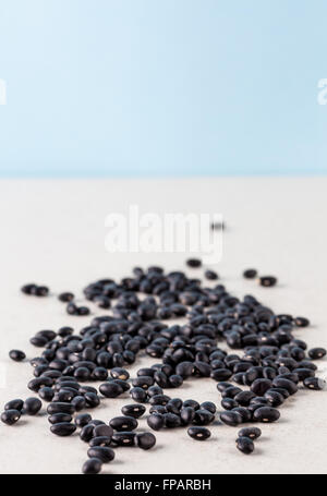 Black turtle beans on bright surface with copy space. Shallow depth of field. Stock Photo