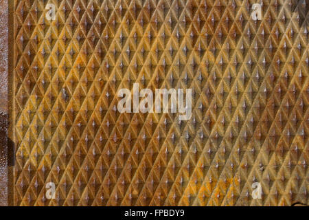 Close-up of waffle textured metal grid on sidewalk Stock Photo