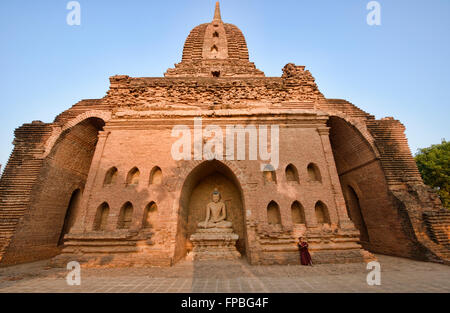 A young monk reading in the temples of Bagan, Myanmar Stock Photo