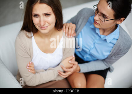 Hopeless young woman visiting psychologist Stock Photo