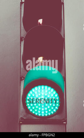 Close up on green traffic light with message SERENITY. Motivational concept image with vintage filter applied Stock Photo