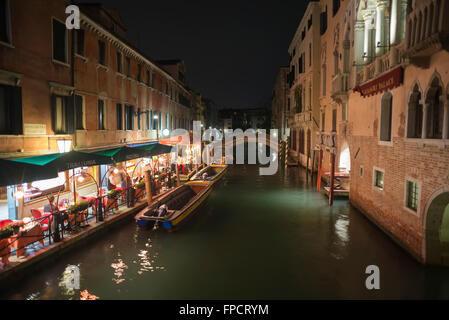 Guests enjoying the romantic atmosphere in the restaurant on the canal Rio di San Lorenzo in the San Marco district in spring Stock Photo