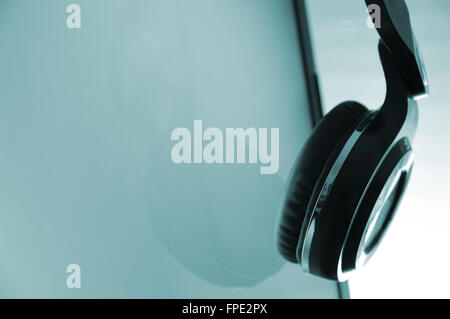 Headphones hanging on a screen. Empty copy space for editor's text. Stock Photo