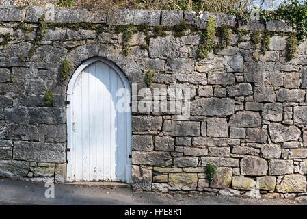 Stone wall gray grey with white wooden gate. Stock Photo