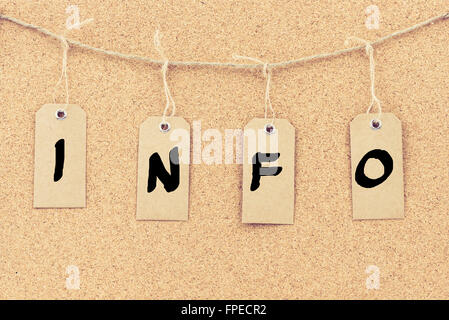 Vintage grunge tags with letters on rope string, word INFO over cork board texture background Stock Photo