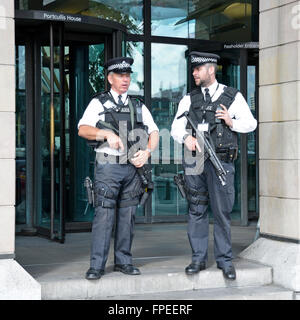 Police Armed UK Metropolitan Police officers holding visible weapons on duty at entrance to Portcullis House at Houses of Parliament London England UK Stock Photo