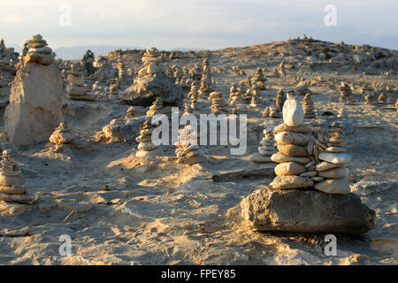 Zen space. Stones. Ses Illetes Beach, Balearic Islands, Formentera, Spain. Backlights in the sunset with stones with different shapes. 'The Flood' ('La Riada'), a unique space built with stones by the German Johannes Schultz. Stock Photo