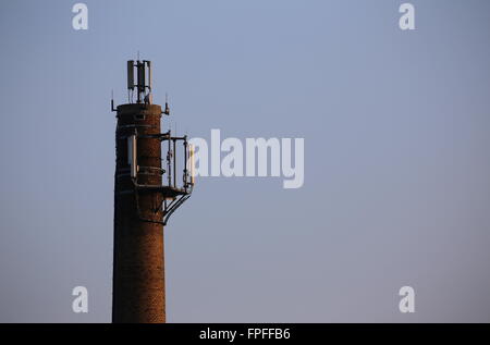 Old chimney used as a base for radio transmitters. Stock Photo