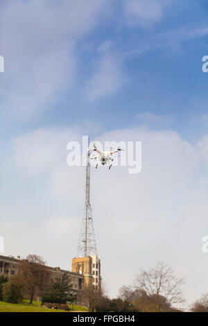 Quadcopter drone in the sky hovering in front of Alexandra Palace and the BBC transmission mast in North London, England Stock Photo