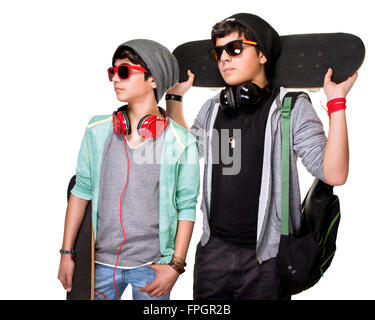 Portrait of two serious boys with skateboards posing in the studio, stylish teens isolated on white background, life of youth Stock Photo