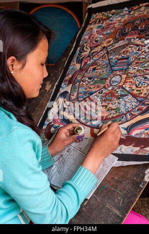 Nepal, Patan.  Young Woman Painting a Thangka, a Tibetan Buddhist Painting. Stock Photo