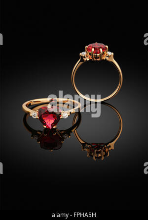 jewelry ring with heart-shaped gem on black background with reflection Stock Photo