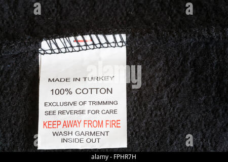 Close up label in black 100 % cotton fleece inflammable garment made in Turkey low cost manufactured product made from natural fibre not fire safe Stock Photo