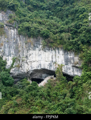 Outside view of Han Sung Sot cave entered high up through a gash in the limestone cliff. Halong Bay, Vietnam Stock Photo