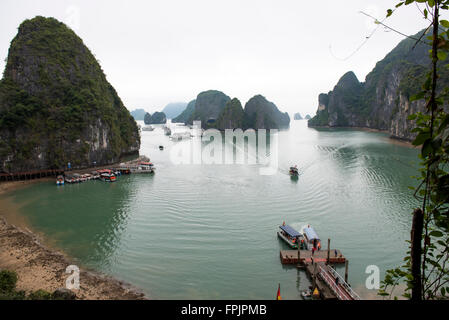 Tourist boats clustering around the harbour to Hang Sung Sot cave.  View of the limestone islands, mist and calm sea Stock Photo