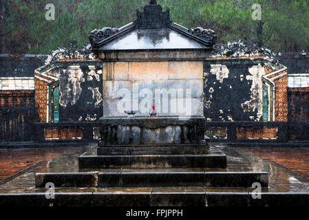 The simple, undecorated, tomb of Emperor Tu Duc, Vietnam, with an incense offering.  On a wet  misty day, in the rain. Stock Photo