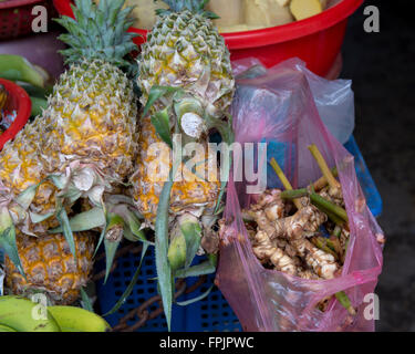 Small pineapples, bananas and fresh galangal for sale in Hoi An market, Vietnam Stock Photo