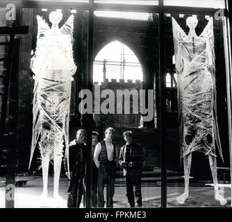 May 18, 1962 - Coventry, England, United Kingdom - Workmen gaze at the Great West Window known as the Screen of Saints and Angels, engraved directly onto the screen in expressionist style by John Hutton, the bottom section of its 70 ft height is left undecorated so that passers-by can look in. In background St Michael's Cathedral now stands ruined, bombed almost to destruction during the Coventry Blitz of 14 November 1940 by the German Luftwaffe. Only the tower, spire, the outer wall and the bronze effigy and tomb of its first bishop, Huyshe Yeatman-Biggs, survived. The ruins of this older cat Stock Photo