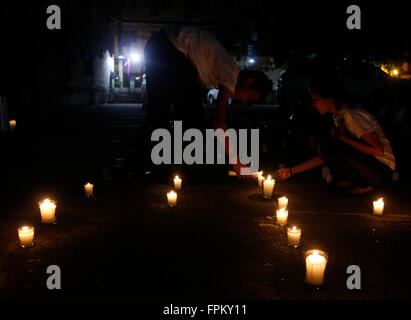 Manila, Philippines. 19th Mar, 2016. A Filipino teenager lights a candle as he participate in candle lighting and praying activity at San Agustin Church as the lights switch-off for Earth Hour 2016. Earth Hour is a worldwide event organized by World Wildlife Fund for Nature that encourage people, communities and businesses to an hour lights-off as a contribution to stop climate change. © Marlo Cueto/Pacific Press/Alamy Live News Stock Photo