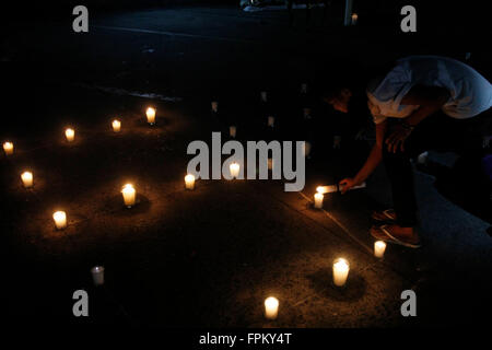 Manila, Philippines. 19th Mar, 2016. A girl lights a candle as she participate in candle lighting and praying activity at San Agustin Church as the lights switch-off for Earth Hour 2016. Earth Hour is a worldwide event organized by World Wildlife Fund for Nature that encourage people, communities and businesses to an hour lights-off as a contribution to stop climate change. © Marlo Cueto/Pacific Press/Alamy Live News Stock Photo