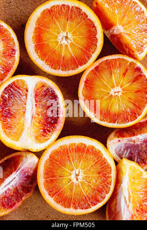 Close up of Sliced Sicilian Blood oranges fruits in brown clay plate. Top view Stock Photo