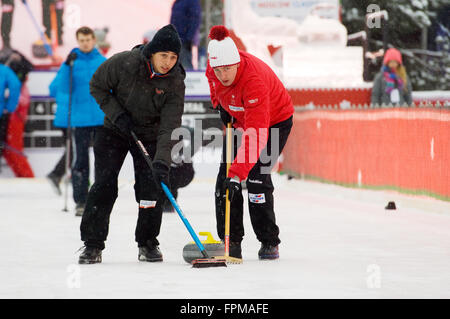 MOSCOW - JANUARY 17, 2016: Curling players M. Pfister (L) and S. Gempeler (R) in action during Russian Curling Champions Tour Moscow Classic 2016 on January 17, in Moscow, Russia, 2016 Stock Photo