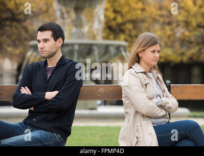 young couple having love fight on the bench in park in Paris, France Stock Photo