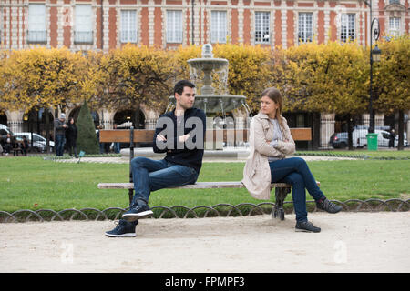 young couple having love fight on the bench in park in Paris, France Stock Photo