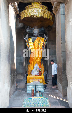 Angkor Wat, Cambodia - January 29 2016: Statue of Buddha in a shrine with incense and offerings in the 12th Century Temple Stock Photo
