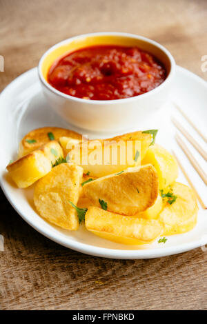 Baked potatoes with a spicy tomato sauce including onions, garlic, bell pepper and hot sauce. Stock Photo
