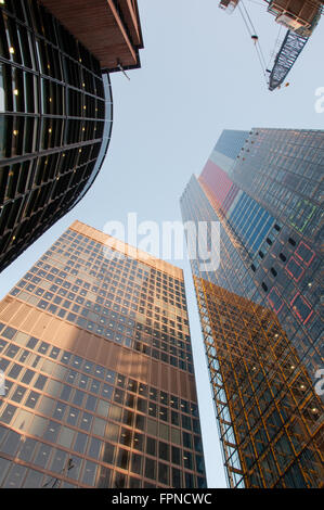 Tall glass metal skyscrapers and metal crane up high blue clear sky in London UK Stock Photo