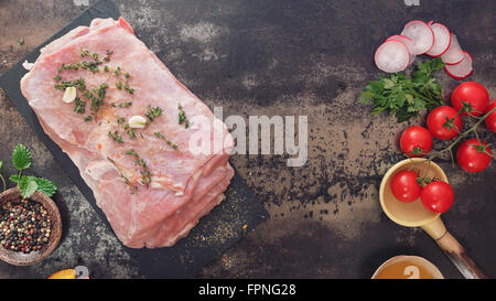 Fresh raw meat with thyme and spices ready for roasting . Top view, vintage toned image, blank space Stock Photo
