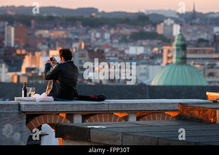 Marolles neighborhood, Brussels, Belgium. A man photographs the roofs of Marollen from near the Palace of Justice. Located in th