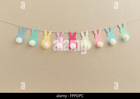 Easter Bunny Banner. Cute bunny shapes with yarn pom pom tails. Stock Photo