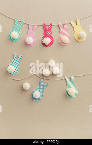 Easter Bunny Banner. Cute bunny shapes with yarn pom pom tails. Stock Photo