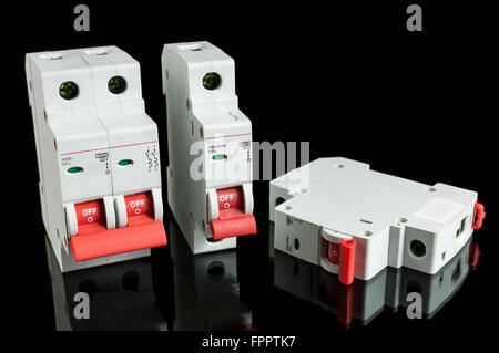 Various automatic circuit breakers, isolated on black background. Electric fuse. Stock Photo