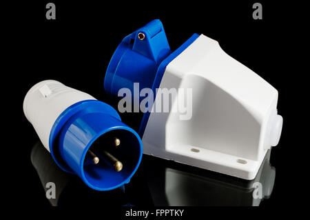 Electric plastic power plug and wall socket with cap isolated on black background Stock Photo