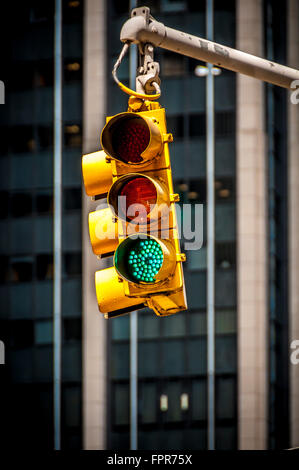 Close-up of a green traffic light in New York City, with a modern office building in the background. USA Stock Photo
