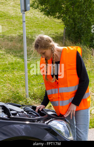 Young woman with her broken down car Stock Photo
