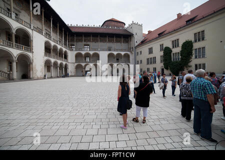 Poland, Krakow (Cracow), Wawel Castle courtyard, group of tourists, people on sightseeing tour, tiered arcades in Renaissance st Stock Photo