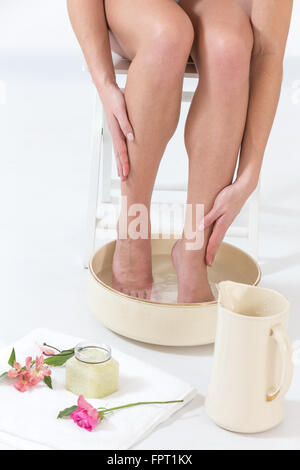 Female relaxing her feet in spa bowl with water Stock Photo