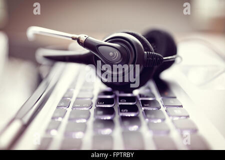 VOIP headset on laptop computer keyboard Stock Photo