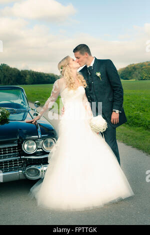 Newlywed couple kissing next to car, Ammersee, Upper Bavaria, Bavaria, Germany Stock Photo