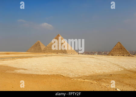 The Pyramids of Giza, man-made structures from Ancient Egypt in the golden sands of the desert with polluted Cairo in the backgr Stock Photo