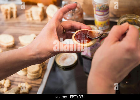 Close-up of a woman hand applying marmalade on cookies, Munich, Bavaria, Germany Stock Photo