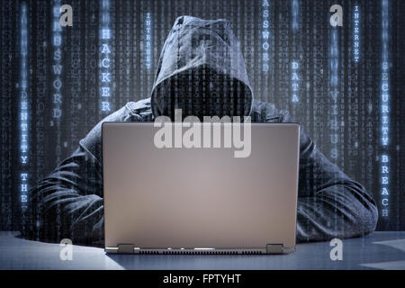 Computer hacker stealing data from a laptop Stock Photo